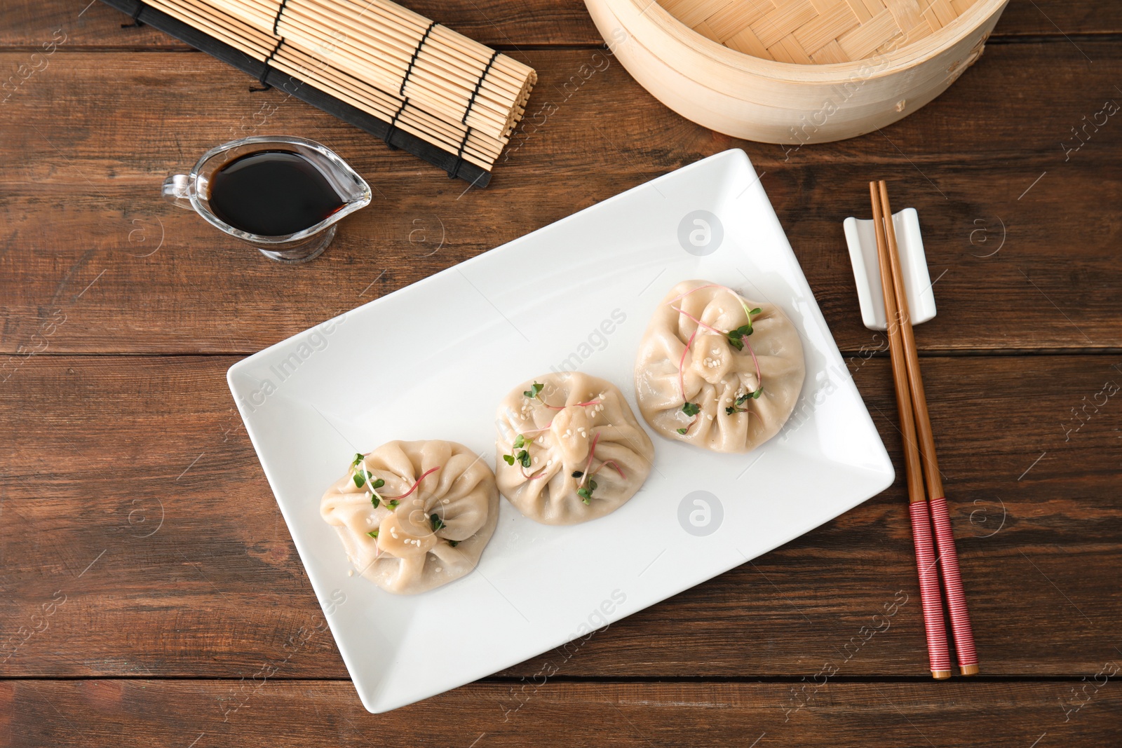 Photo of Plate with tasty baozi dumplings served on table, top view