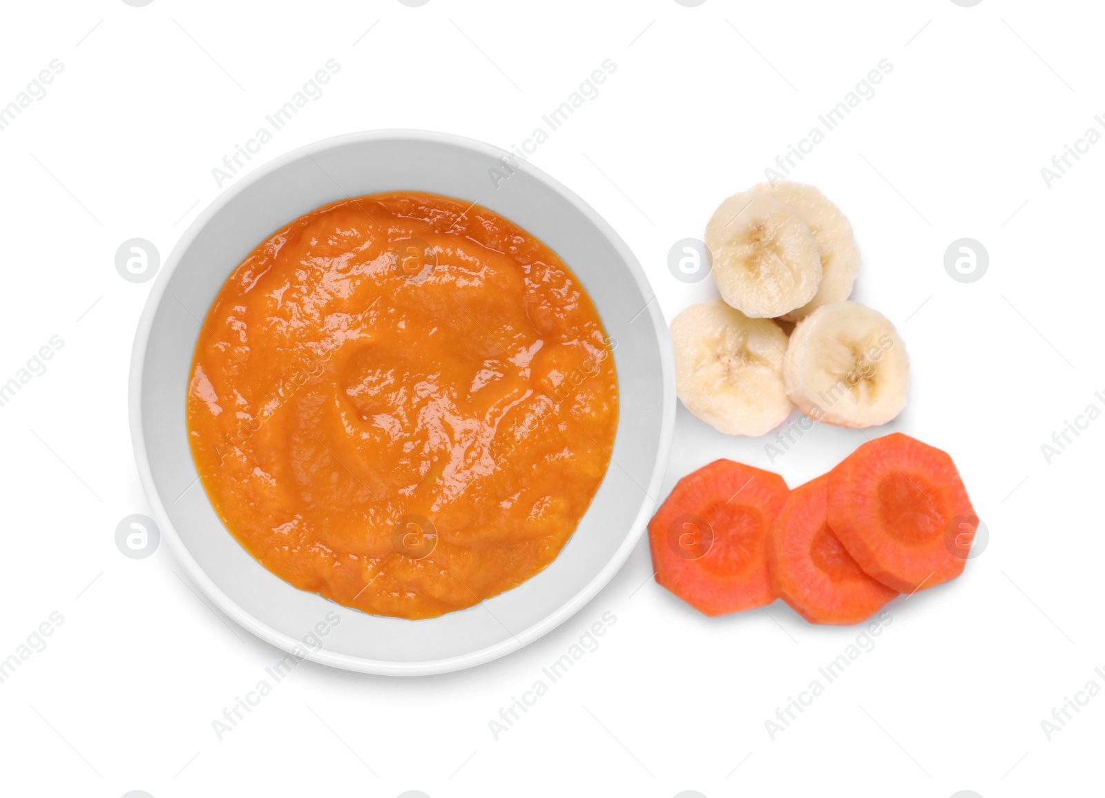 Photo of Bowl with healthy baby food and ingredients isolated on white, top view