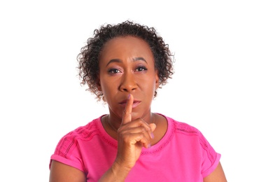 Portrait of African-American woman making silent gesture on white background