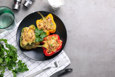 Photo of Tasty stuffed bell peppers served on grey table, flat lay. Space for text