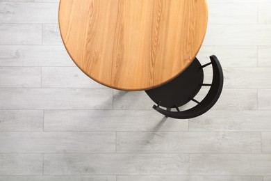 Empty wooden table and chair indoors, top view. Stylish furniture