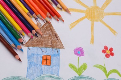 Cute child`s drawing and colorful pencils, flat lay