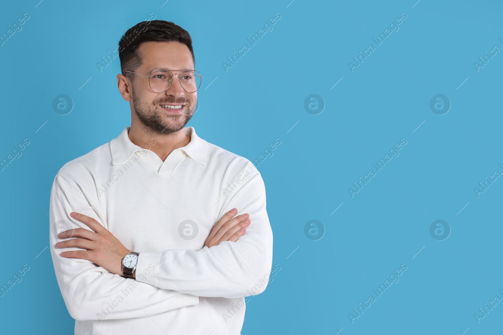 Photo of Portrait of happy man in stylish glasses on light blue background. Space for text