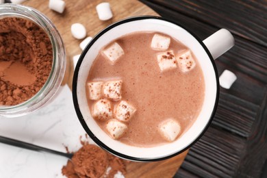 Cup of aromatic hot chocolate with marshmallows and cocoa powder served on table, top view