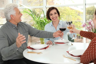 Photo of People with glasses of wine at table in restaurant