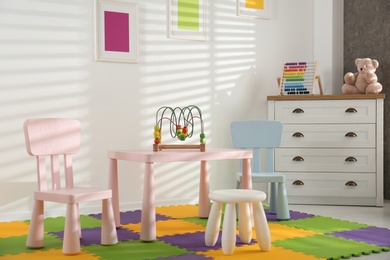 Photo of Stylish playroom interior with toys and modern furniture