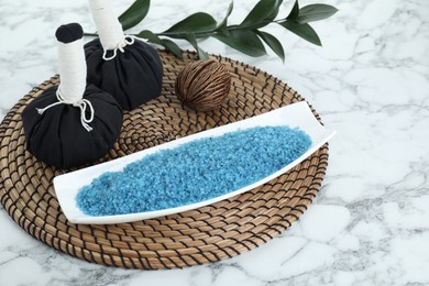Photo of Composition with blue sea salt and herbal bags on white marble table