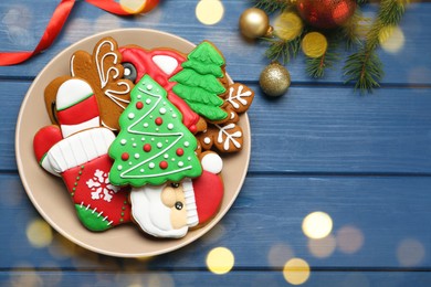 Photo of Different tasty Christmas cookies and decor on blue wooden table, flat lay. Space for text