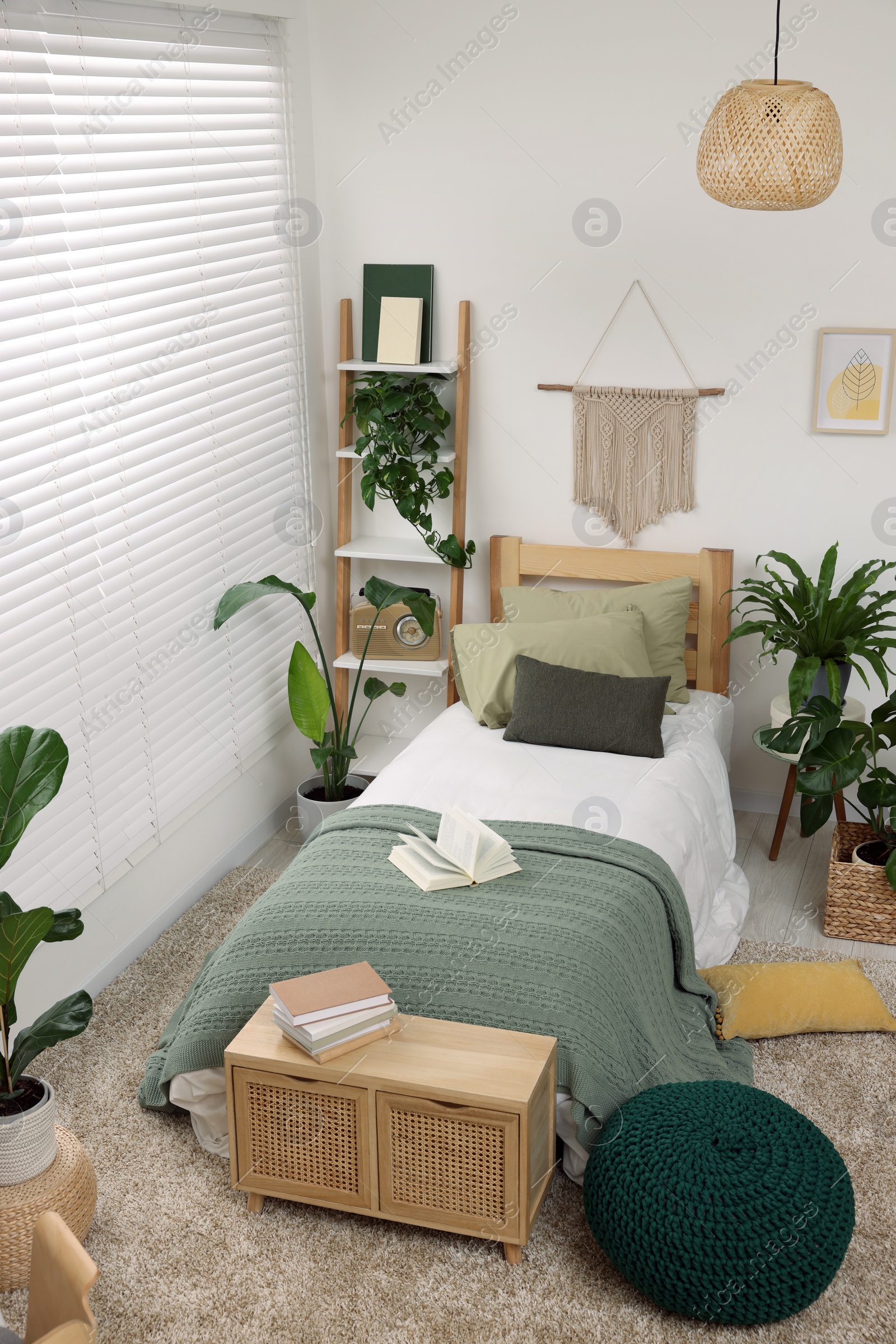 Photo of Large comfortable bed and potted houseplants in stylish bedroom. Interior design