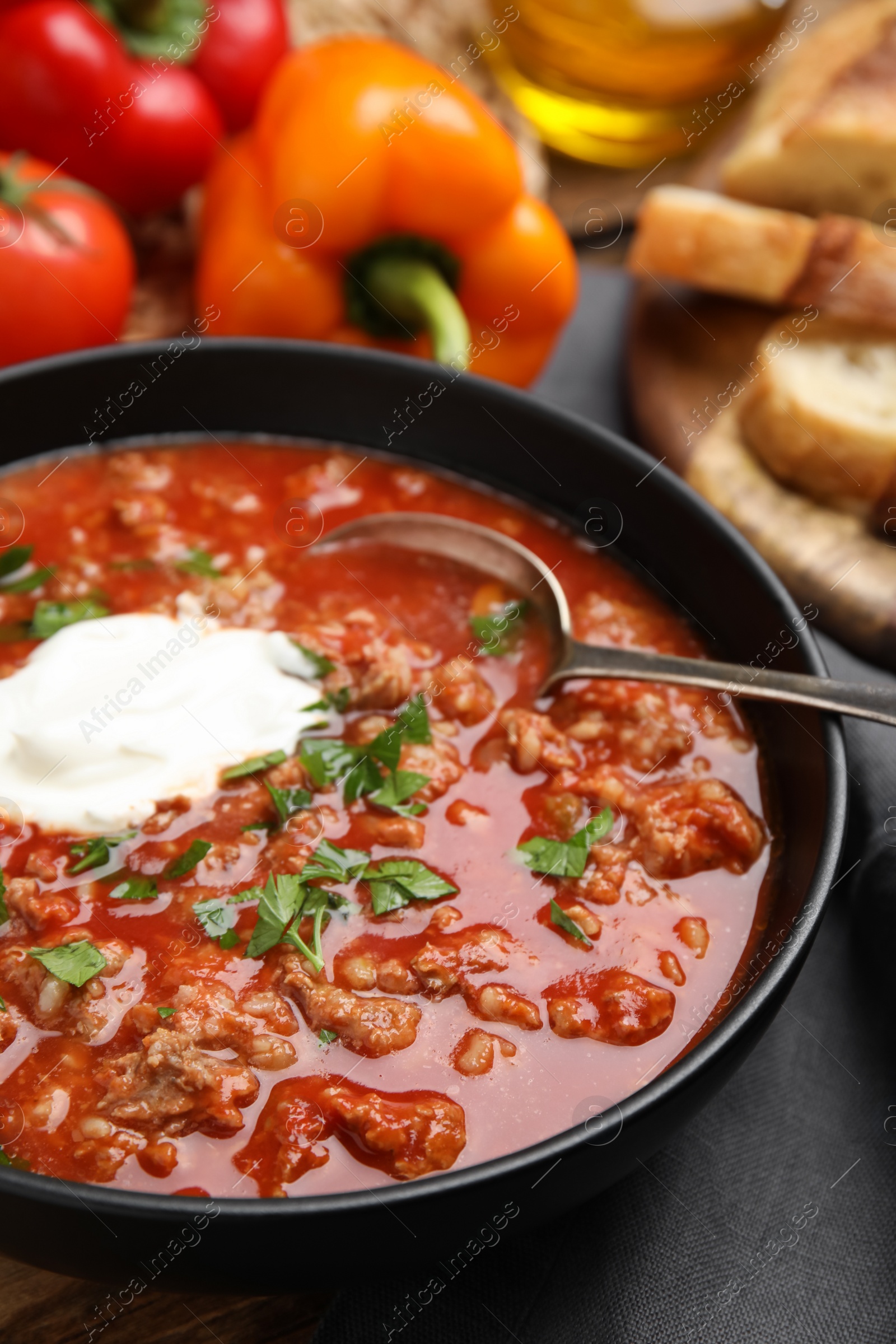 Photo of Bowl of delicious stuffed pepper soup on table, closeup