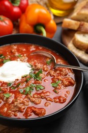 Photo of Bowl of delicious stuffed pepper soup on table, closeup