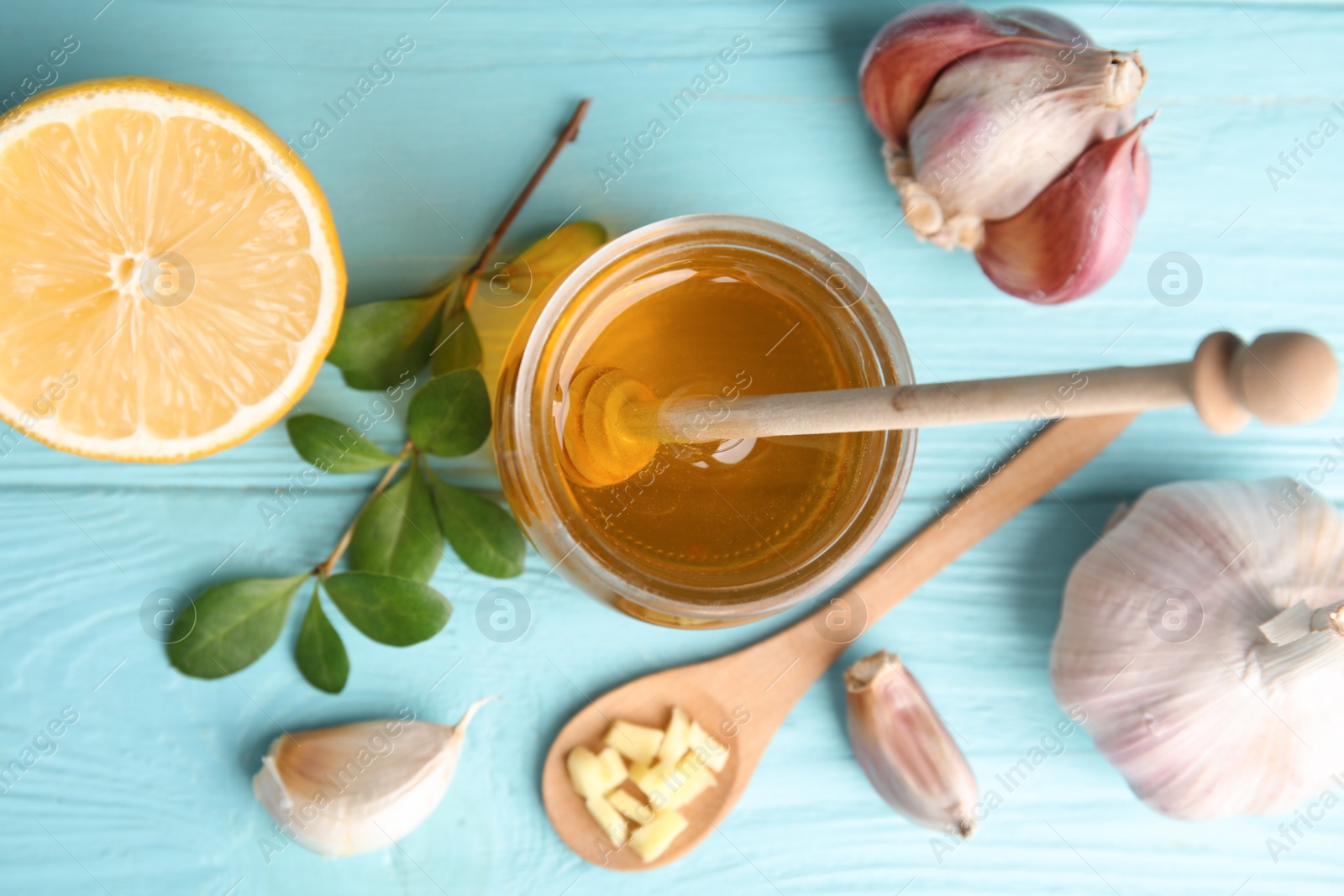 Photo of Flat lay composition with garlic and other cold remedies on blue wooden table