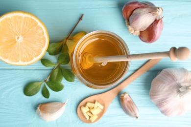 Flat lay composition with garlic and other cold remedies on blue wooden table