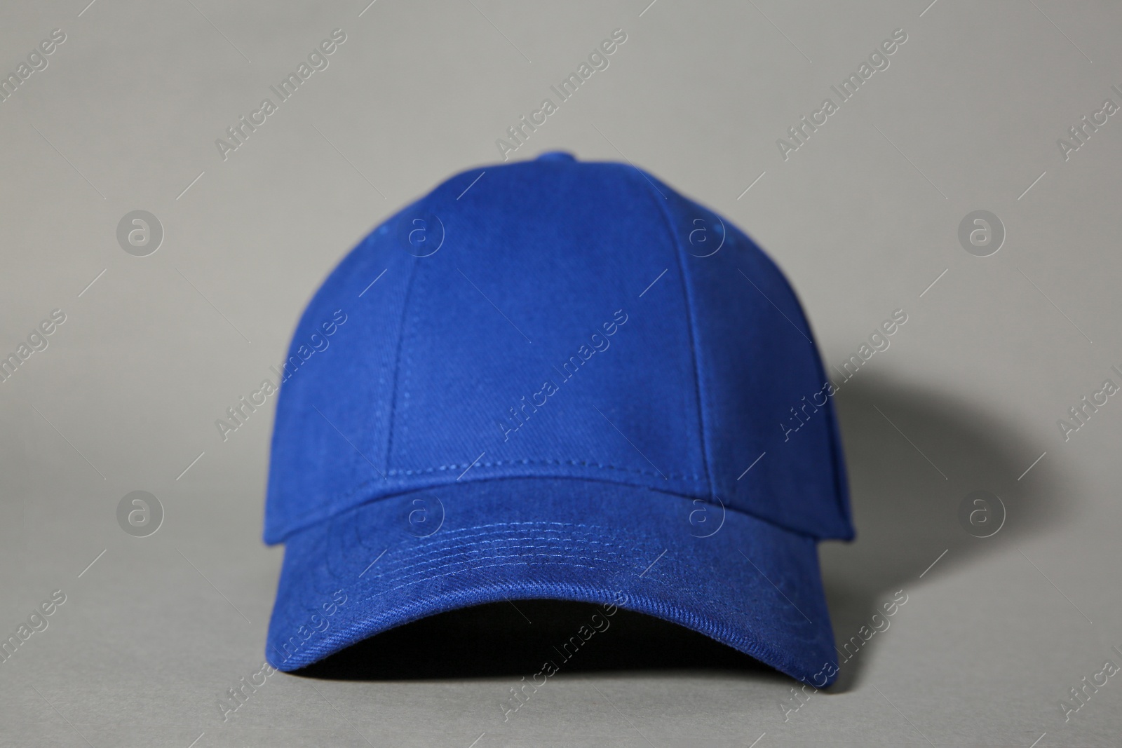 Photo of Stylish blue baseball cap on grey background