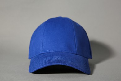 Photo of Stylish blue baseball cap on grey background