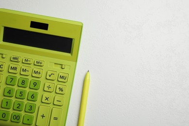 Calculator and pen on white table, top view. Space for text