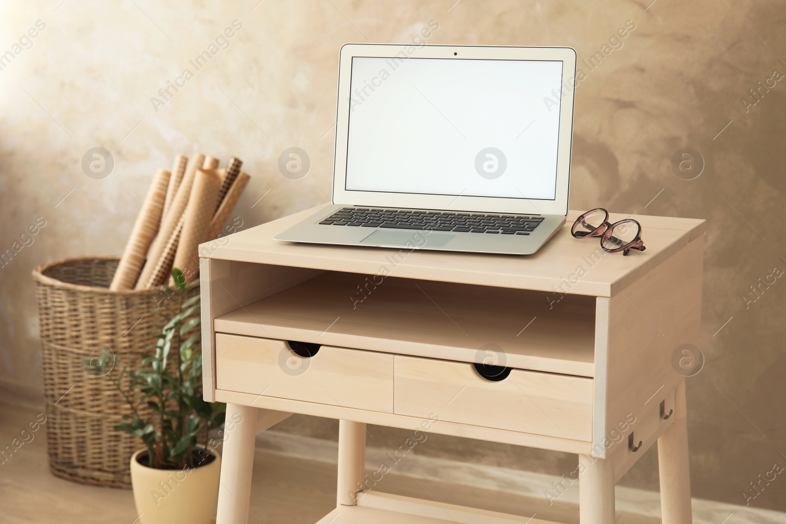 Photo of High wooden table with laptop as stand up workplace in modern interior