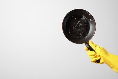 Photo of Woman holding dirty frying pan on white background, closeup. Space for text