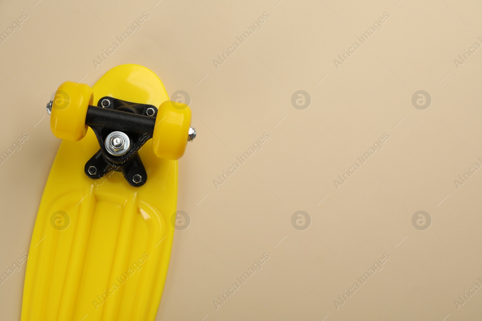 Photo of Skateboard on beige background, top view. Space for text