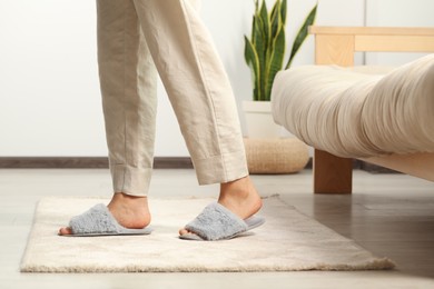 Photo of Woman wearing soft slippers at home, closeup
