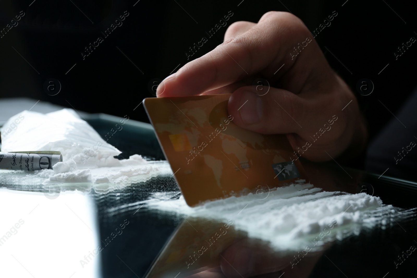 Photo of Drug addict taking cocaine at table, closeup view