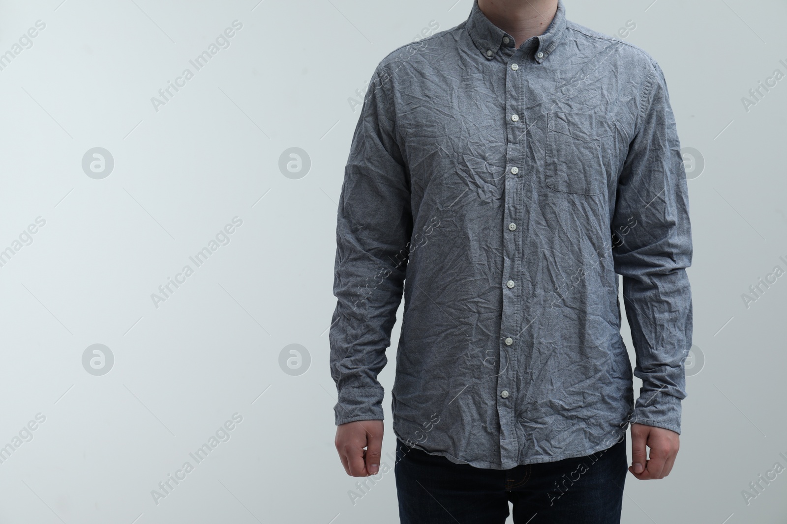 Photo of Man wearing creased shirt on light background, closeup. Space for text