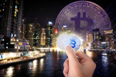 Man holding bitcoins against digital scheme and cityscape, closeup