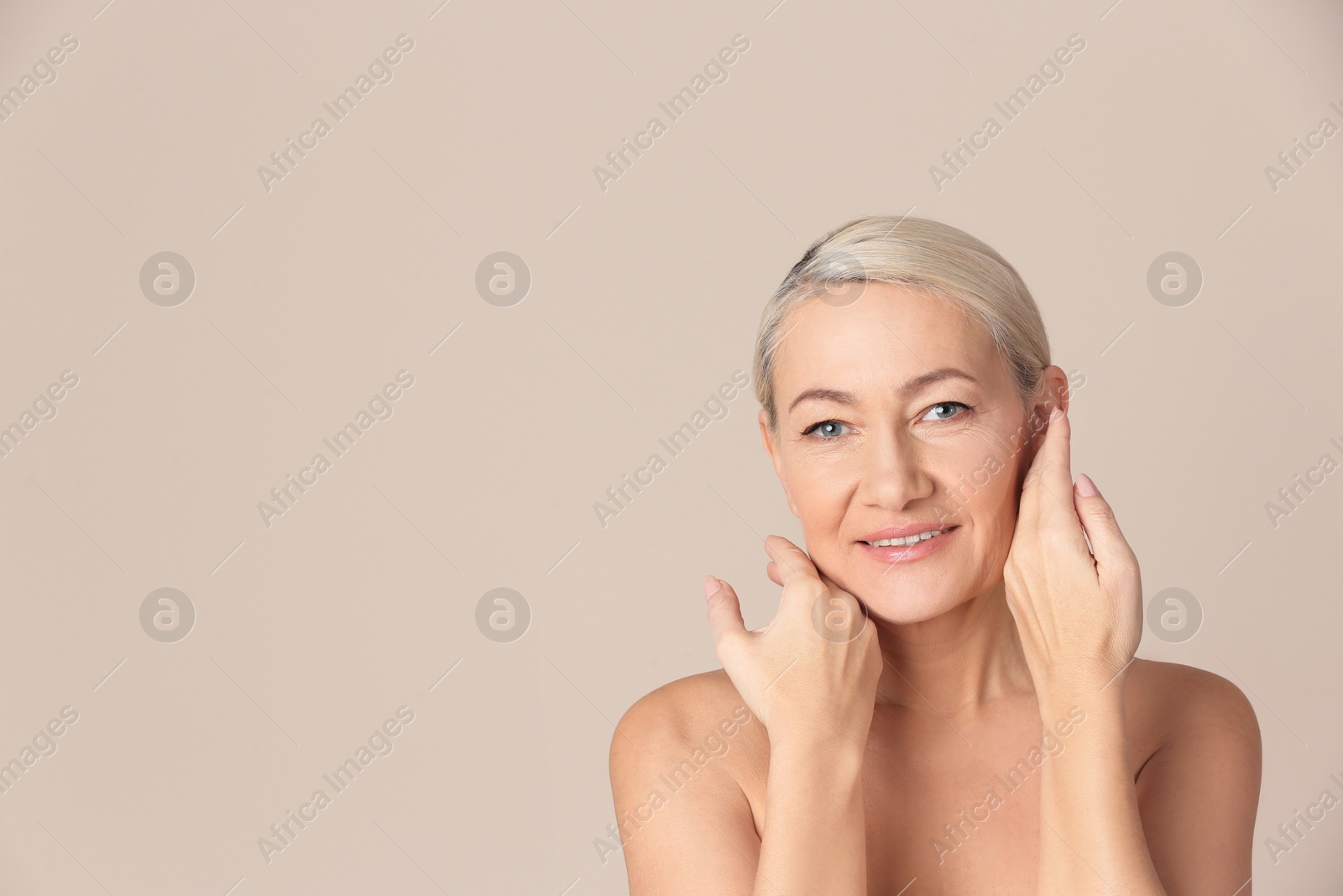 Photo of Portrait of beautiful mature woman on beige background. Space for text