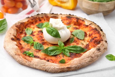 Delicious pizza with burrata cheese and basil on table, closeup