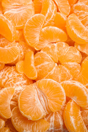 Photo of Fresh juicy tangerine segments as background, top view