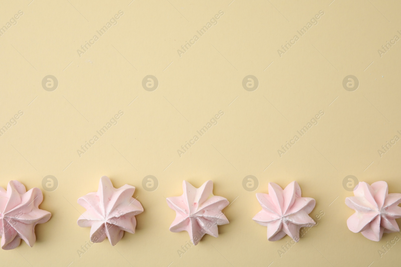 Photo of Delicious meringue cookies on beige background, flat lay. Space for text