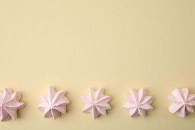 Photo of Delicious meringue cookies on beige background, flat lay. Space for text