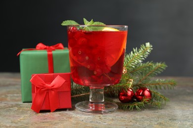 Aromatic Christmas Sangria in glass, gift boxes and festive decor on textured table