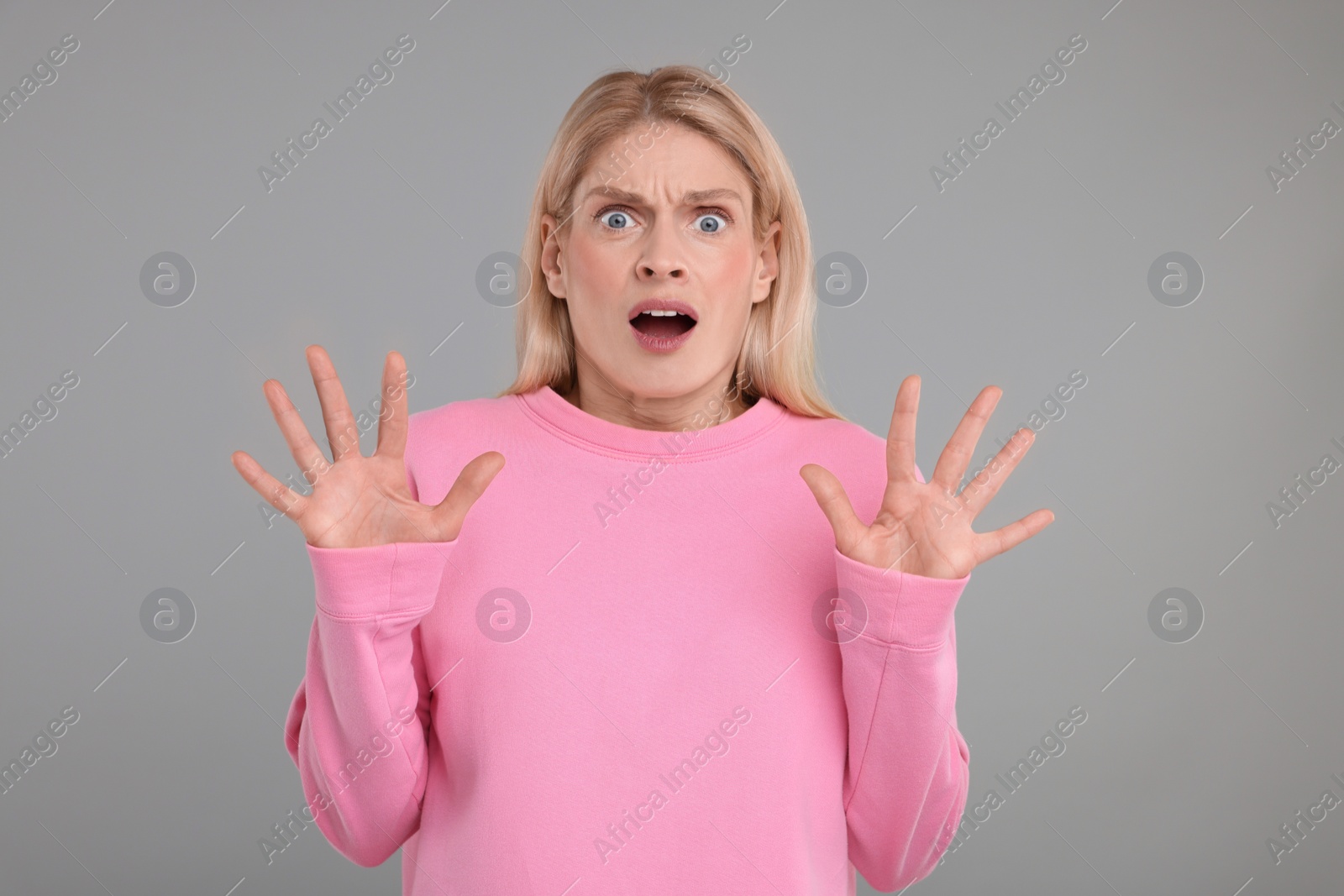 Photo of Portrait of surprised woman on grey background