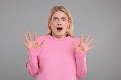 Portrait of surprised woman on grey background