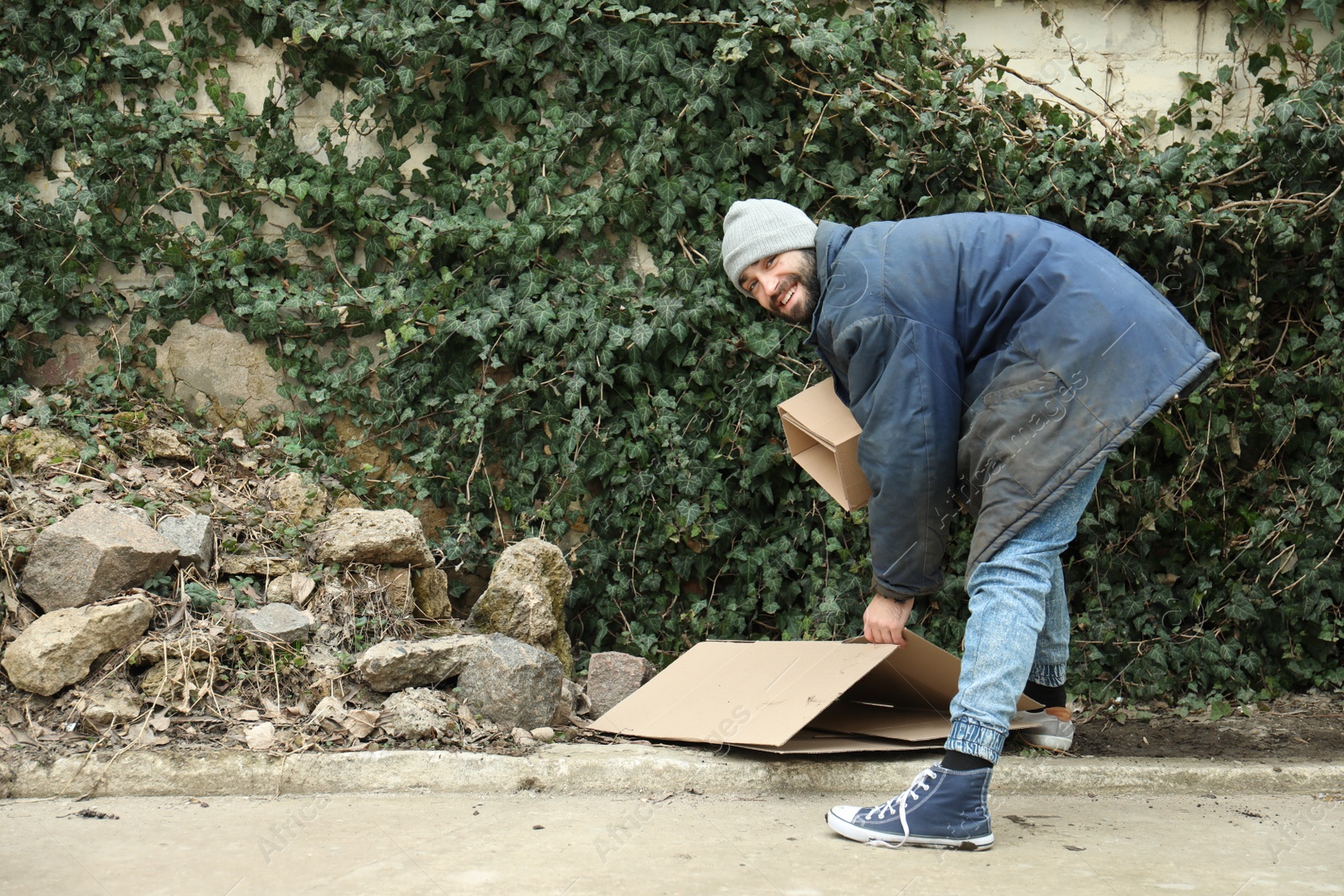 Photo of Poor homeless man with cardboard on street