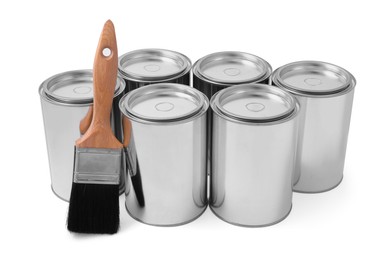 Photo of Cans of paints and brush on white background