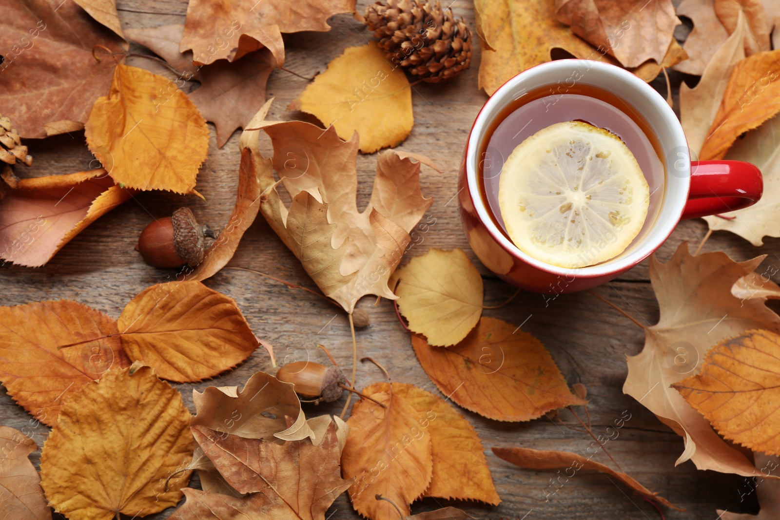 Photo of Flat lay composition with cup of hot drink on wooden table. Cozy autumn atmosphere