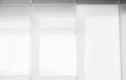Large window with white roller blinds indoors