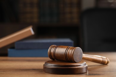 Photo of Wooden gavel on table against blurred background
