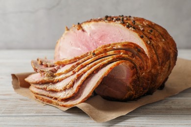 Photo of Delicious sliced baked ham on white wooden table, closeup