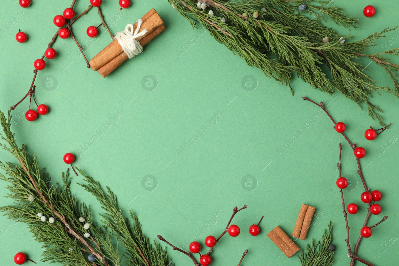 Photo of Christmas flat lay composition with conifer branches and berries on green background, space for text. Winter holidays