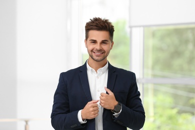Photo of Portrait of handsome young man in elegant suit indoors