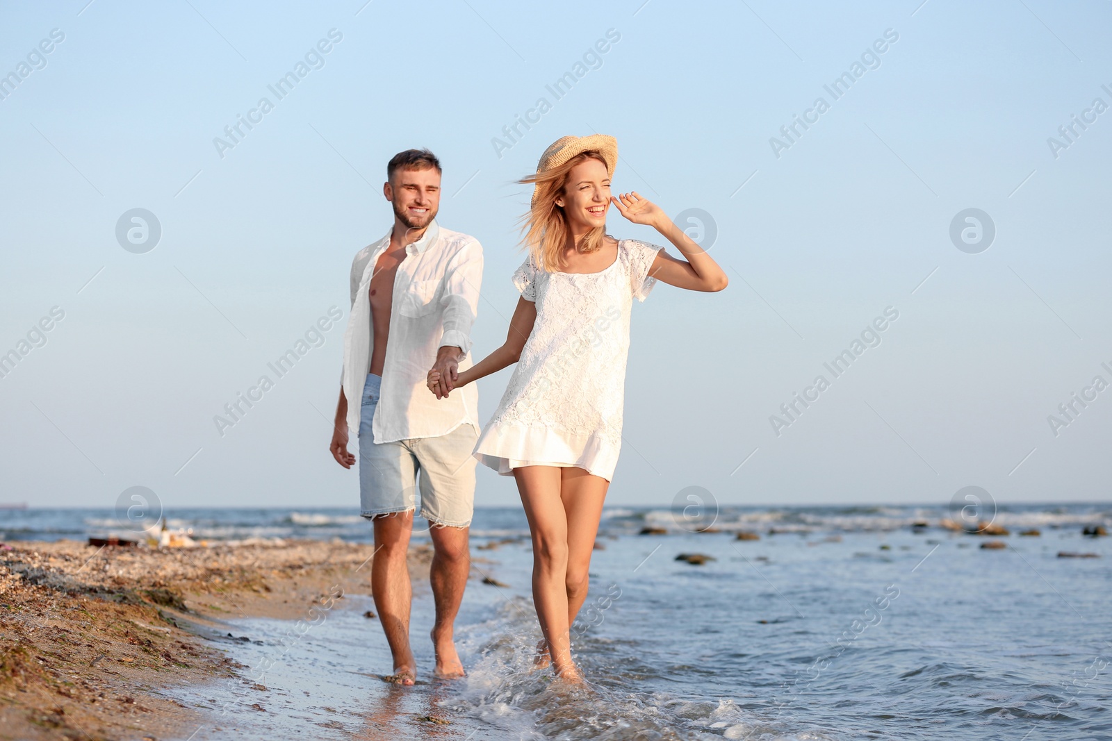 Photo of Young couple spending time together on beach