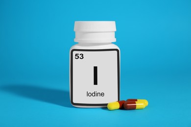 Photo of Bottlemedical iodine and pills on light blue background