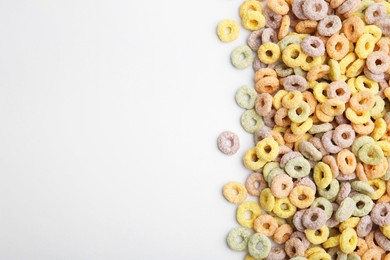 Photo of Tasty cereal rings on white background, flat lay. Space for text