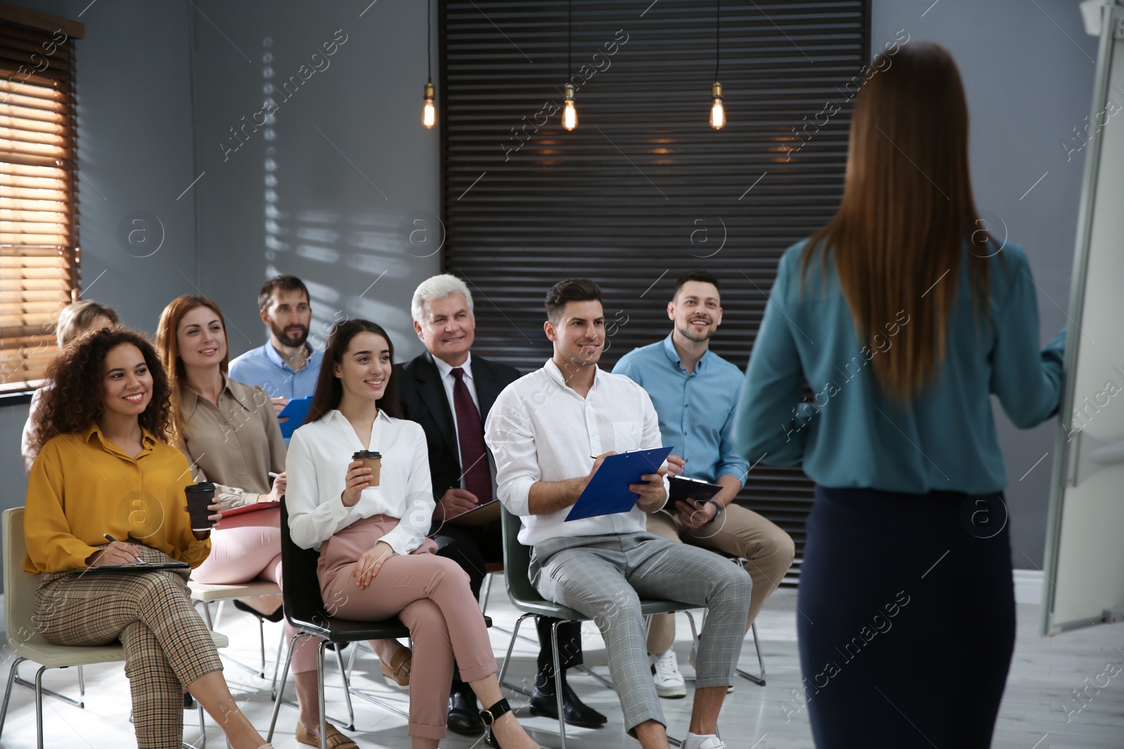 Photo of Business trainer answering questions at seminar in conference hall