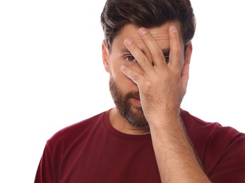 Photo of Embarrassed man covering face with hand on white background