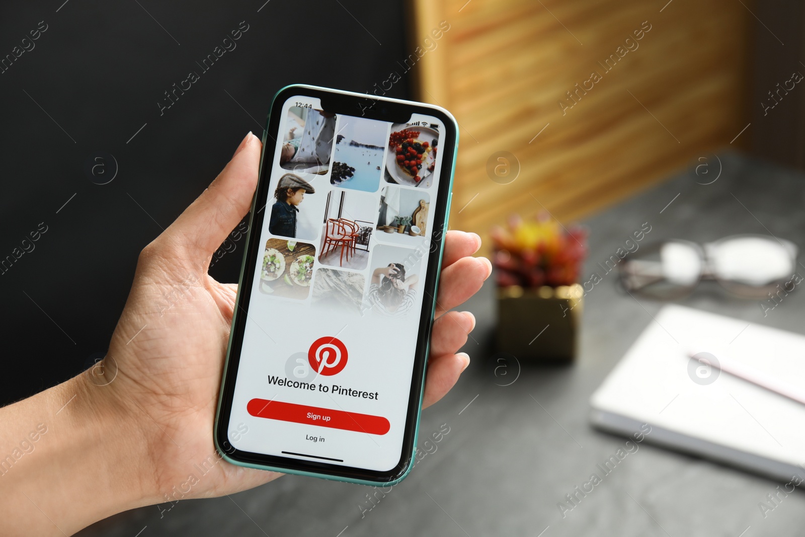 Photo of MYKOLAIV, UKRAINE - JULY 9, 2020: Woman holding Iphone 11 with Pinterest app on screen indoors, closeup. Space for text