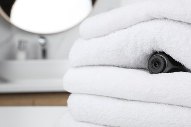 Photo of Camera hidden between towels in bathroom, space for text